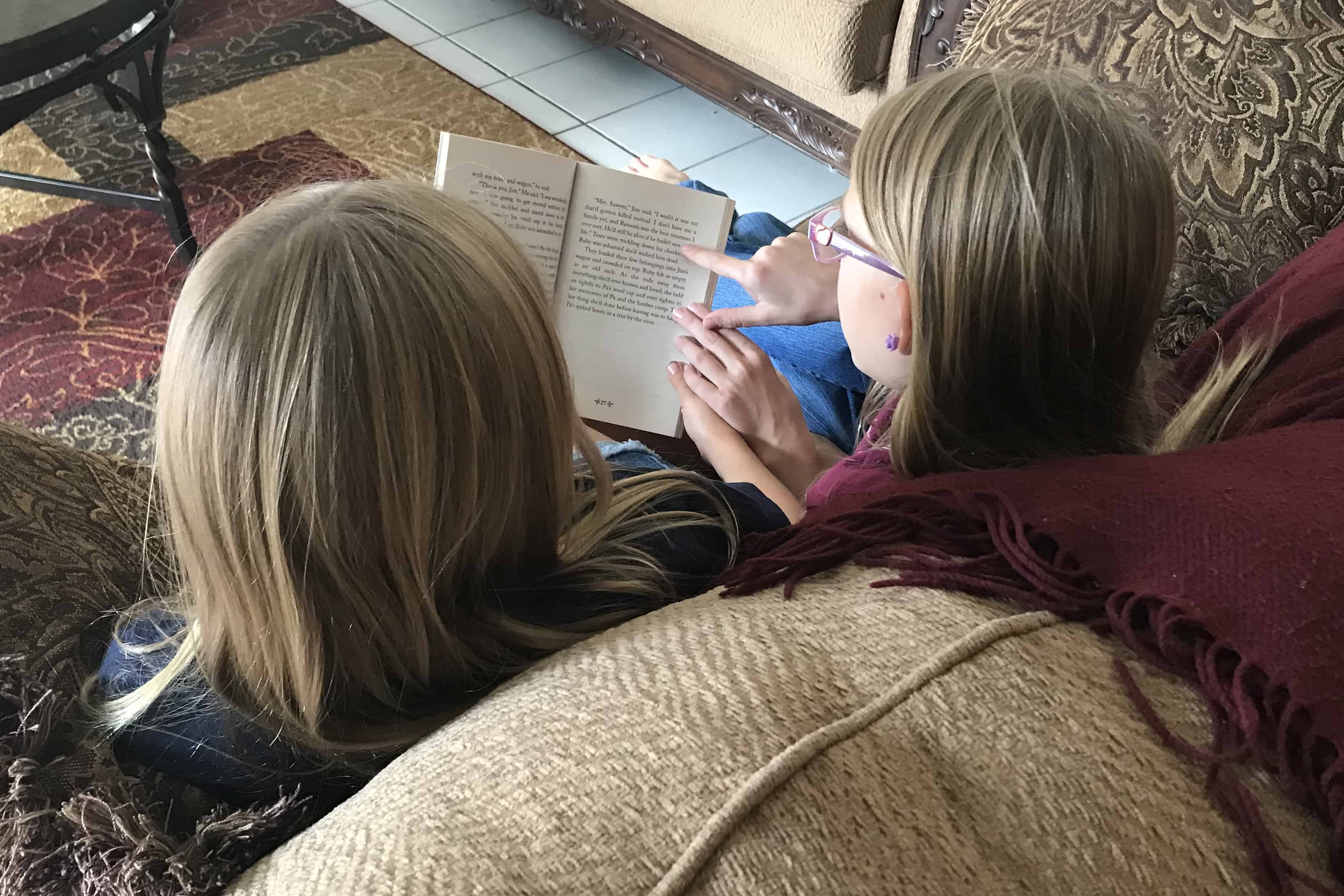 Two girls reading on couch